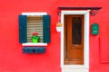 Door and window with flower on the red facade of the house Royalty Free Stock Photo