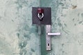 Door with aluminium handle and padlock. Touched green sheet metal door detail