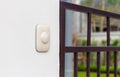 Doorbell or buzzer on mounted white wall with modern home in the background Royalty Free Stock Photo