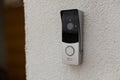 Doorbell on the wall of the house with a surveillance camera