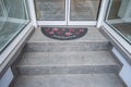 Doormat at an entrance of a shop store that is empty and closed with red flowers and the text Welcome, Germany