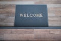 A doormat with the word Welcome rests on the floor to welcome people entering