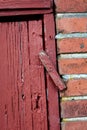 Doors. Closeup of an old red wooden door in a face brick building,most likely a house in a residential district. A latch Royalty Free Stock Photo
