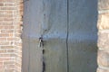 An old iron door on the lock of a brick building Royalty Free Stock Photo