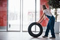Doors is opening. Woman walks with brand new wheel to the car. Conception of repair Royalty Free Stock Photo