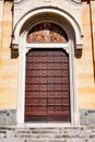 The doors to the divine temple, brown with patterns in a white opening, under a fresco depicting saints.