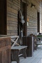 The doorstep of an old wooden house with a wooden door, a beautiful wooden bench, a wooden table and shoes Royalty Free Stock Photo