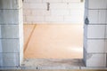 Doorway in aerated concrete wall. Entrance to a room with bare walls made of aerated concrete bricks. Subfloor made of oriented