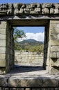 Doorway in stone wall looks out to mountains and blue sky with w Royalty Free Stock Photo