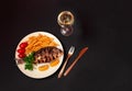 Dorado fish and glass of white wine on dark background. View from above, copy space Royalty Free Stock Photo