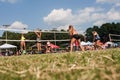 Low Angle Young Women Competing In Triples Grass Volleyball Tournament