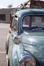 A green Morris Minor car with luggage on the roof