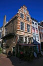 View on old crooked red gabled brick stone house in historical town center against blue summer sky