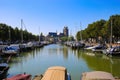 View on dutch water canal with yacht harbour, gothic church background against blue summer sky