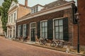 Facade of elegant brick buildings and bicycles on the street in a cloudy day at Dordrecht. Royalty Free Stock Photo