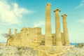 Doric temple of Athena Lindia on Acropolis of Lindos Rhodes, Greece. Front view of columns and walls. near tree grows