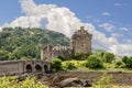 Eilean Donan Castle, a symbol of Scottish heritage, stands near the water edge, with an ancient stone bridge Royalty Free Stock Photo