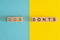 Dos and Donts concept. Wooden blocks typography in bright blue and yellow background.