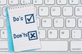 Dos and Donts message blue notepad on gray keyboard Royalty Free Stock Photo