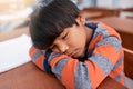 he dosed off quickly. a tired elementary school child sleeping on his desk in the classroom.