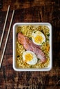 Doshirak fast food on a dark background. Instant noodles with egg, sausages and spices. Homemade ramen. Traditional Chinese food. Royalty Free Stock Photo