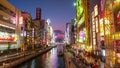 Dotonbori canal with illuminated buildings at sunset near the shopping district Namba, Osaka, Japan