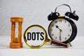 DOTS EST abbreviation of Dynamic On Time Solutions text with alarm clock, magnifying glass and hour glass on wooden background Royalty Free Stock Photo