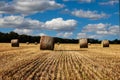 Straw bales on the field under blue sky with white clouds Royalty Free Stock Photo