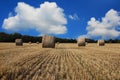 Straw bales on the field under blue sky with white clouds Royalty Free Stock Photo