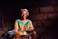 Douala Cameroon - 06 august 2018: closeup of old african lady in her rural home kitchen with traditional dress looking in camera