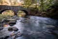 Double Arch stone bridge over gently flowing Flatbrook River in Stokes State Forest, NJ, in fall Royalty Free Stock Photo