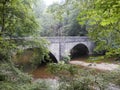 Double arched stone bridge over stream from below