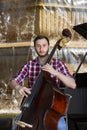 Double bass player playing contrabass Image on the background of the city Royalty Free Stock Photo