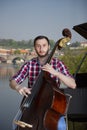 Double bass player playing contrabass Image on the background of the city Royalty Free Stock Photo