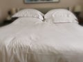 Double bed filled with white linens with big pillows. Royalty Free Stock Photo