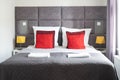 double bed with headboard, cushions and gray cover in hotel room Royalty Free Stock Photo