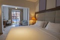 Double bed in suite of a luxury hotel room with terrace and pool view Royalty Free Stock Photo