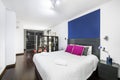 Double bedroom with gray wooden headboard, black bookcase,