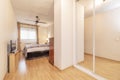 Double bedroom with white edged sliding mirrored wardrobe with large bed and wooden floorboards