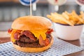 Double beef burger with cheese and bacon, bowl of fries