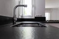 A double bowl stainless steel kitchen sink in a modern style, steel chrome water tap in the kitchen, water consumption Royalty Free Stock Photo