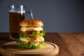 Double burger with cheese, salad, cutlets and glass of beer Royalty Free Stock Photo