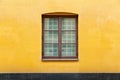 Double casement window on yellow concrete wall