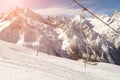 Double-chair ski lift on the background of the Caucasus Mountains ridge on a sunny winter day