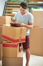 Double-checking that everything was delivered. a young man signing a document for the delivery of his cardboard boxes.