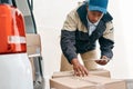 Double-checking his orders for delivery. a courier using a digital tablet while sorting boxes from a delivery van. Royalty Free Stock Photo