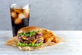 Double cheeseburger with fried potatoes and a glass of cola Royalty Free Stock Photo