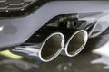 Double chrome exhaust pipe of powerful sport car with grey plastic details Royalty Free Stock Photo