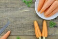 Double cut carrots and white plate with tasty ripe carrot on wooden table, closeup Royalty Free Stock Photo