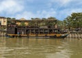 Double decker floating restaurant tied along the shore of the Thu Bon River in Hoi An, Vietnam